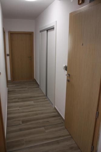 een lege hal met een deur en een kamer met houten vloeren bij Apartment AmongUs in Dubrovnik