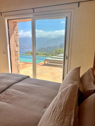a bedroom with a large glass door to a pool at Les Demeures de Piana in Piana