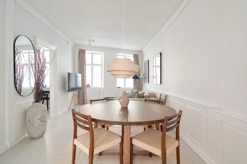a dining room with a wooden table and chairs at Cozy Apartments in Heart of Copenhagen Near Strøget & Højbro Plads in Copenhagen