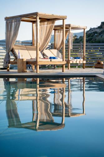 a pool with a gazebo and chairs on the water at Bee Home by A&D Properties in Porto Rafti
