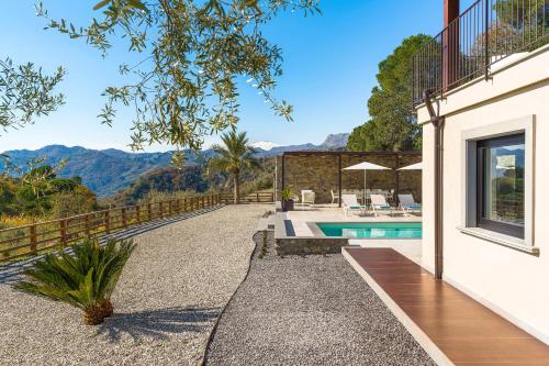a house with a swimming pool and mountains in the background at Zagara Bianca in Savoca 