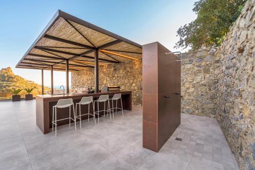 an outdoor kitchen with a bar and a stone wall at Zagara Bianca in Savoca 