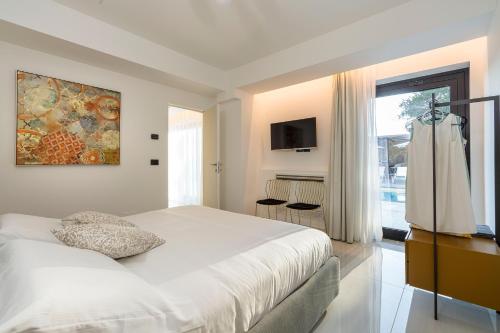 a bedroom with a large white bed and a window at Zagara Bianca in Savoca 