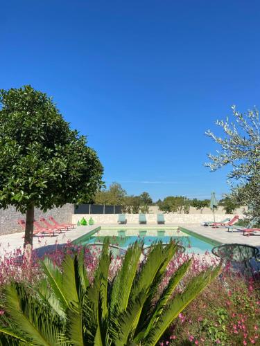 a swimming pool with a lot of plants and flowers at Agriturismo B&B TorreBianca in Manduria