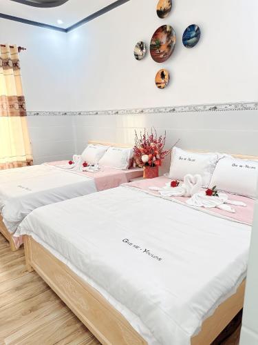 duas camas num quarto com flores em Nhà Nghỉ 86 Hàm Tiến em Phan Thiet