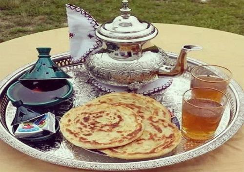 a silver tray with two pancakes and a teapot on a table at Modern Moroccan apartment near the beach in Safi in Safi
