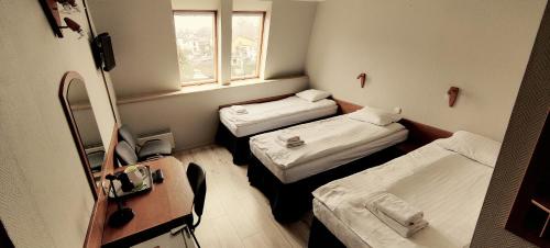 Cette petite chambre comprend 2 lits et une fenêtre. dans l'établissement Hotel Kliper, à Władysławowo