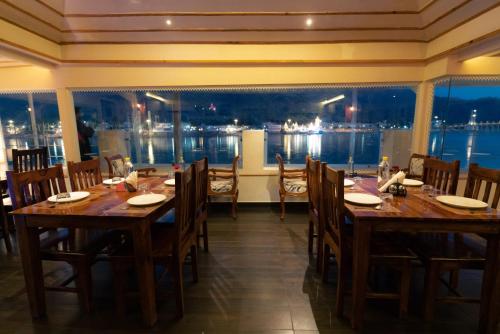 a restaurant with tables and chairs and a view of the water at Yog Niketan By Sanskriti in Rishīkesh