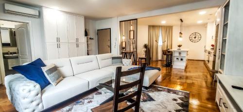 a living room with a white couch and blue pillows at Americano in Brčko