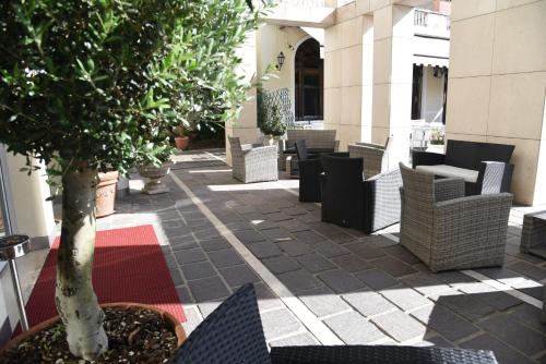 a patio with chairs and a tree on a building at HOTEL DUCA D'AOSTA in Mogliano Veneto