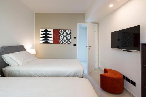 a bedroom with two beds and a flat screen tv at Zagara Bianca in Savoca 