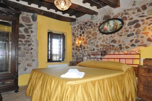 um quarto com uma cama grande e uma colcha amarela em PODERE BEATRICE 20P large pool, WiFi near 5 Terre em Bardine di San Terenzo Monti