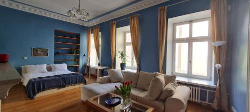 ein Wohnzimmer mit einem Sofa und einem Bett in der Unterkunft ReHouse- Didzioji 39 in Vilnius