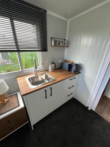 a small kitchen with a sink and a window at Raglan Seaview Cabin in Raglan