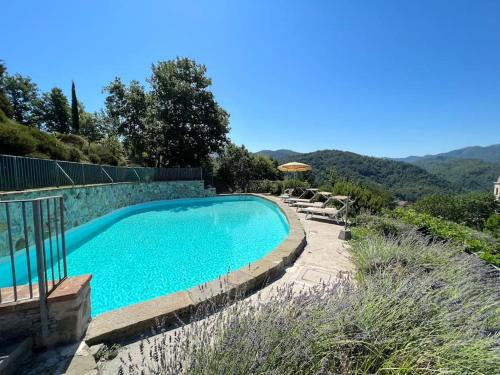 uma piscina com cadeiras e um guarda-sol em PODERE BEATRICE 20P large pool, WiFi near 5 Terre em Bardine di San Terenzo Monti