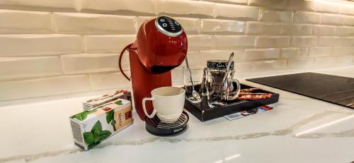 a red blender sitting on top of a counter with a cup at Americano in Brčko