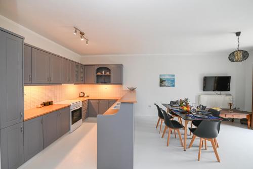 a kitchen and dining room with a table and chairs at Santamare Apartment in Agios Sostis