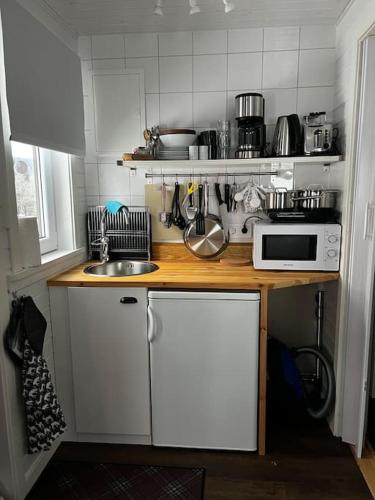 a small kitchen with a microwave and a sink at Stuga i Transtrand in Transtrand
