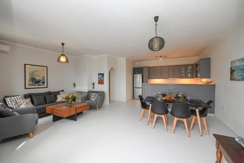 a living room and kitchen with a couch and a table at Santamare Apartment in Agios Sostis