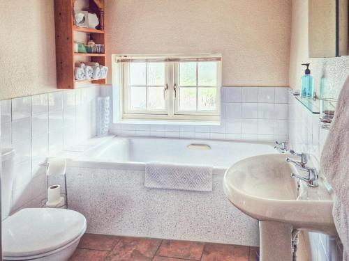 ein Badezimmer mit einer Badewanne, einem WC und einem Waschbecken in der Unterkunft The Mansion Cottage in Tetford