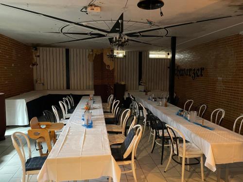 a row of long tables in a room with chairs at Hotel Schwarzer Adler in Heilbad Heiligenstadt