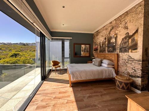 a bedroom with a bed and a large window at Luxury Home located on Pinnacle Point Golf Estate in Mossel Bay