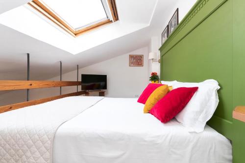 una camera da letto con un letto bianco con cuscini rossi e gialli di Corallo a Spello