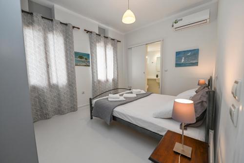 1 dormitorio con 1 cama y 1 mesa con lámpara en Santamare Apartment, en Agios Sostis