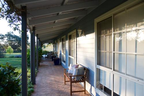 a porch of a house with a bench on it at Marigold Cottage, A Blue Mountains Oasis- Spacious, Views & Kangaroos in Little Hartley