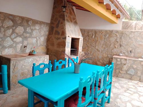 uma mesa azul e cadeiras em frente a uma parede de pedra em Finca Los Villegas em Castril