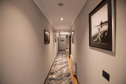 a hallway with paintings on the walls at Sky View Hotel in Korçë