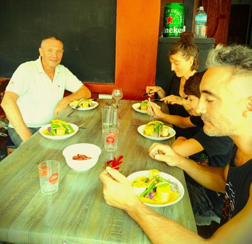 a group of people sitting at a table eating food at Dee-Dee's Guest House, Bed And Breakfast in Pakse