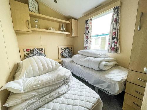 מיטה או מיטות בחדר ב-Lovely Caravan At Broadland Sands Holiday Park Nearby Lowestoft Ref 20011bs