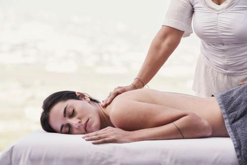a woman getting a massage from a therapist at Apikia Santorini in Pirgos