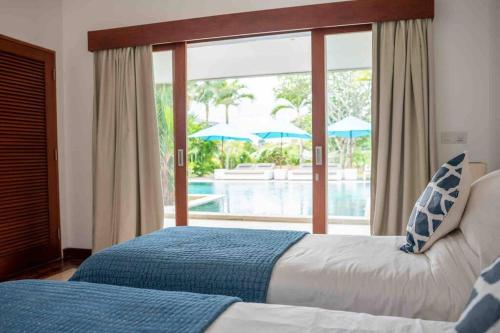 a bedroom with two beds and a view of a pool at Villa Mimpi Nyata in Canggu