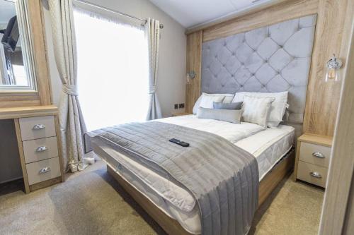 ein Schlafzimmer mit einem großen Bett und einem Fenster in der Unterkunft Beautiful Lodge With Full Sea Views At Broadland Sands In Suffolk Ref 20235bs in Hopton on Sea