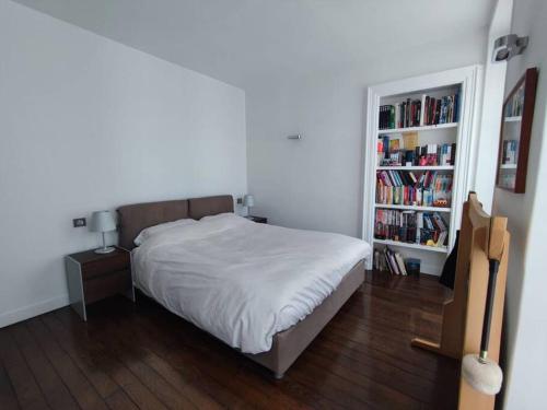 sypialnia z łóżkiem i półką z książkami w obiekcie Air conditioning Paris central stylish apartment w Paryżu