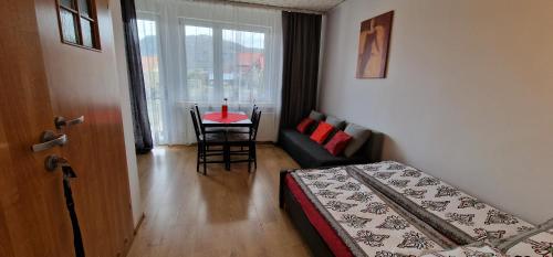 シュツァブニツァにあるSzczawnica noclegi U Basiのベッド、テーブル、ソファが備わる客室です。