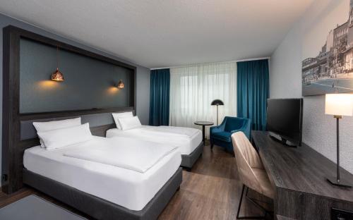 ein Hotelzimmer mit 2 Betten und einem TV in der Unterkunft City Hotel Berlin East in Berlin
