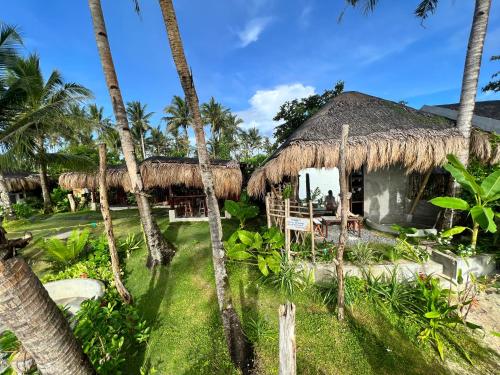 um resort com palmeiras em frente em shakabrah beach club cottage em General Luna