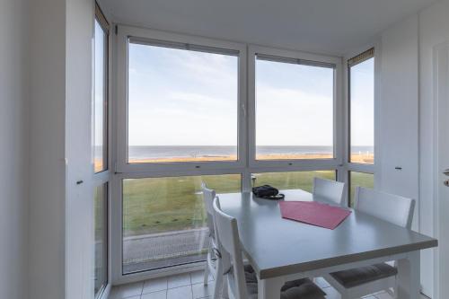 ein Esszimmer mit einem Tisch und einem Fenster in der Unterkunft Ferienwohnung 8 im Haus Horizont in Cuxhaven