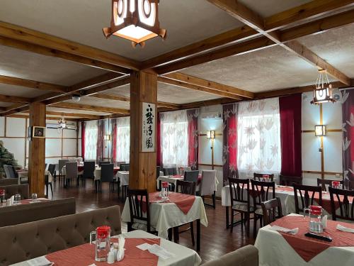 a restaurant with tables and chairs and a chandelier at Green Hotel in Atyraū