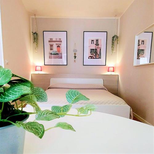 Al Glicine Apartments في لازيسي: غرفة نوم بسريرين ومصنع خزاف