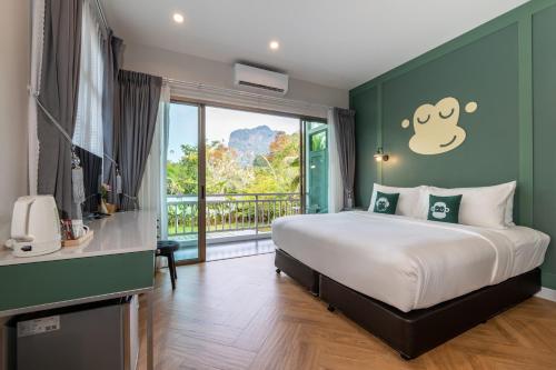 Tha Lane Bay的住宿－Blu Monkey Pooltara Krabi Hotel & Villas Pet Friendly，一间卧室设有一张床和一个大窗户