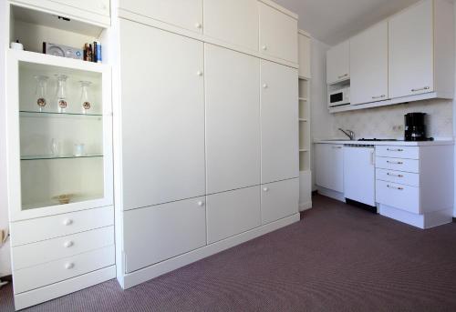 クックスハーフェンにあるHaus Seehuette Wohnung 401の白いキッチン(白いキャビネット、コンロ付)