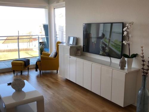 een woonkamer met een grote flatscreen-tv bij Strand Palais 20 in Cuxhaven