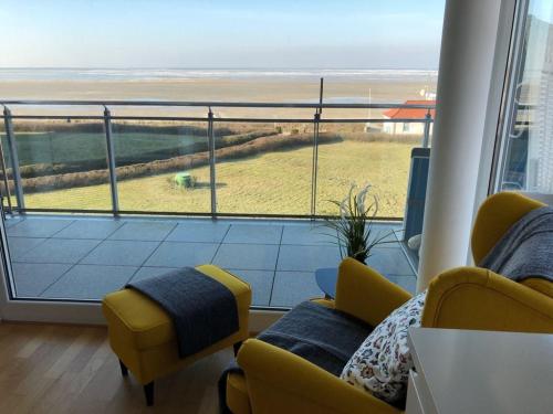 een kamer met 2 stoelen en uitzicht op de oceaan bij Strand Palais 20 in Cuxhaven