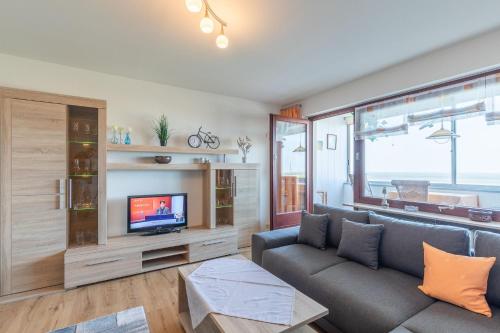 ein Wohnzimmer mit einem Sofa und einem TV in der Unterkunft Am Sahlenburger Strand Wohnung 8 in Cuxhaven