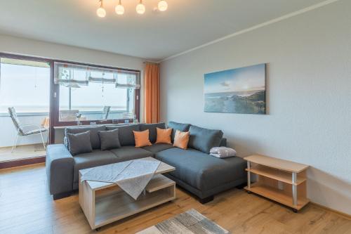 ein Wohnzimmer mit einem Sofa und einem Tisch in der Unterkunft Am Sahlenburger Strand Wohnung 8 in Cuxhaven