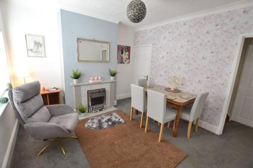 a living room with a table and chairs and a fireplace at Church View in Quorndon